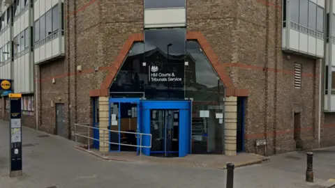 Google Exterior of south London tribunal brick building with clue door and sign above reads 'HM Courts and Tribunals Service'