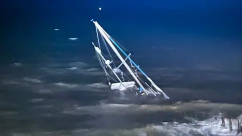 The sail of a sunken boat sticking out of the water. 