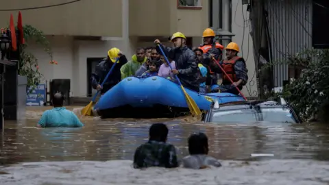 Beveiligingspersoneel van Reuters gebruikt een opblaasbaar vlot om bewoners in veiligheid te brengen vanuit een overstroomd gebied nabij de oever van de Bagmati-rivier, die overstroomt na zware regenval, in Kathmandu, Nepal.