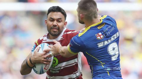 Wigan's Bevan French and Warrington's Danny Walker contest a tackle