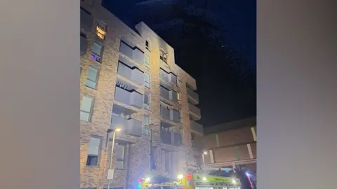 Fire damage can just be seen in a blown-out window on the top floor 