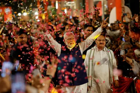 Adnan Abidi/Reuters Supporters throw petals on Indian Prime Minister Narendra Modi 