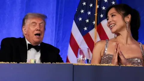 Trump reacts next to CBS News senior White House correspondent and White House Correspondents' Association President (WHCA) Weijia Jiang at the WHCA Dinner