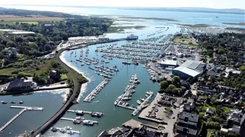 PA Media An aerial picture of Lymington Harbour. A huge number of boats of various sizes are docked. 