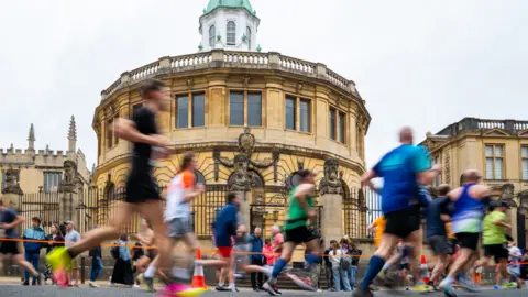 Hoards of runners pass Oxford's Sheldonian Theatre.