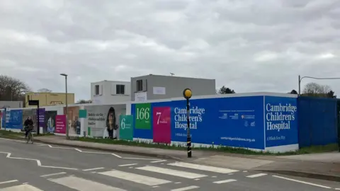 LDRS Hoarding on the side of a road advertising the new Cambridge Children's Hospital being built. The hoarding encases the build site.