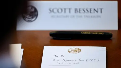 Reuters A notepad in front of U.S. Secretary of the Treasury Scott Bessent reads "To Do Buy Japanese Yen $5-10 bil" as he participates in a cabinet meeting at Camp David, Maryland, U.S., July 31, 2026.