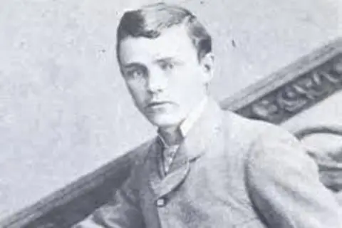 Getty Images A headshot of a youthful-looking Robert Ford. He looks directly at the camera. He has a short back-and-sides haircut and is wearing a buttoned-up jacked and shirt. 