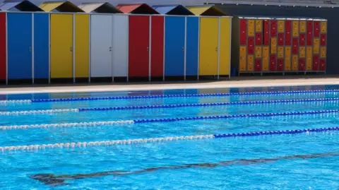 South Downs Leisure Swimming pool lanes in a lido with colourful changing huts