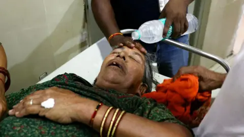 Getty Images A hospital staff member pours water on the face of a patient suffering from heat stroke at a government hospital during a severe heatwave in Varanasi on May 30, 2024. Extreme temperatures across India are having their worst impact in the country's teeming megacities, experts said on May 30, warning that the heat is fast becoming a public health crisis. India is enduring a crushing heatwave with temperatures in several cities sizzling well above 45 degrees Celsius (104 degrees Fahrenheit). (Photo by Niharika KULKARNI / AFP) (Photo by NIHARIKA KULKARNI/AFP via Getty Images)