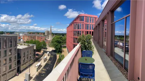A view from the balcony of the Forum in Gloucester. There is a road beneath the balcony with some office buildings on the other side.