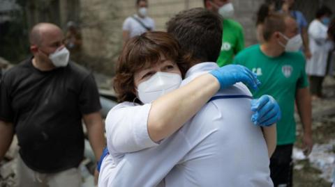 Healthcare workers embrace after the attack in Kyiv