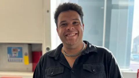 Josiah Eloi smiling wearing a black shirt