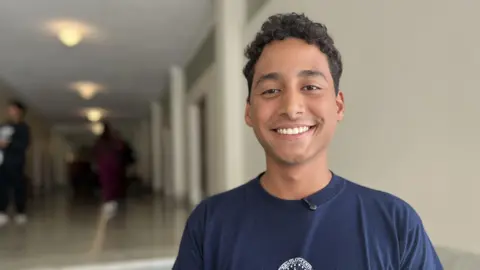 Samuel Arias, a university student smiles into the camera. 