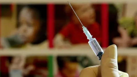 A nurse handling a jab needle