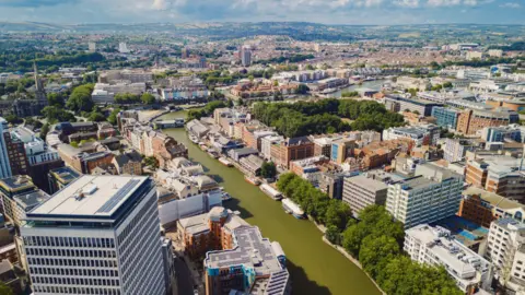 Drone view of the city of Bristol, captured above Feeder Road, showing a green-coloured River Avon dividing the north and south of the city.