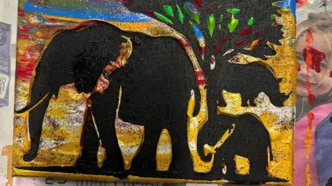 Rowen Saunders A canvas showing black elephants, a rhino and a tree with a colourful background