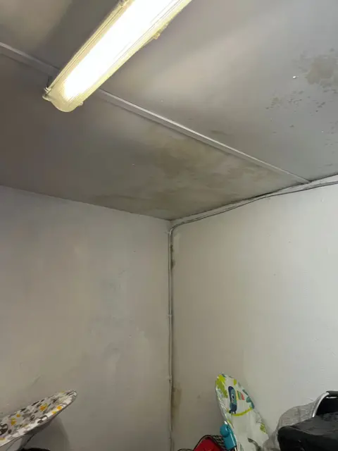 West Marsh Baby Bank A white wall and ceiling covered in mould and damp patches