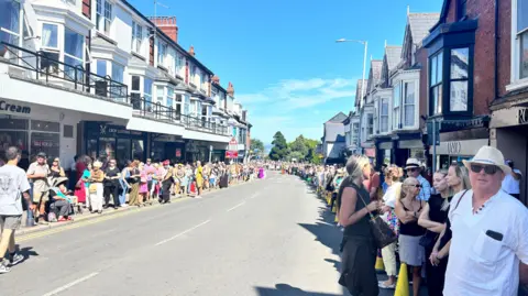 Hundreds of people lining the streets in Mumbles, Swansea. 