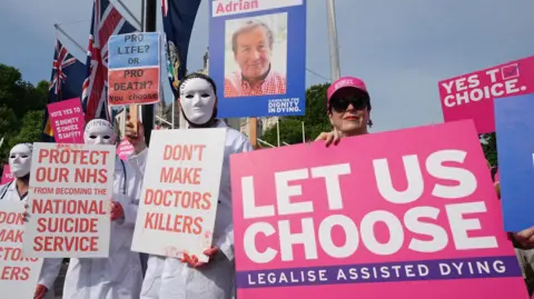 Campaigners holding placards who support and oppose the assisted dying bill demonstrate at Parliament Square in Westminster ahead of the debate in the House of Commons