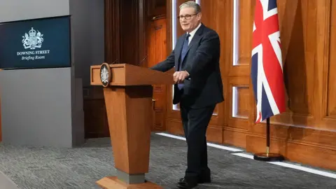 Prime Minister Keir Starmer stands behind a podium and speaks during a press conference at Downing Street on April 1, 2026 in London, England. 