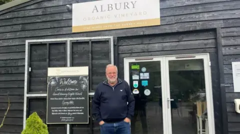 ADRIAN HARMS/BBC Nick Wenham, owner of Albury Organic Vineyard, outside the building to his vineyard