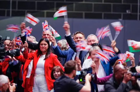 PA Media Cabinet ministers wave flags during Prime Minister Sir Keir Starmer's keynote speech at the Labour Party Conference at the ACC Liverpool. Picture date: Tuesday September 30, 2025.