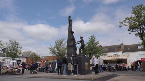 The Shirebrook mining memorial, which is surrounded by people amid the town's Market Place