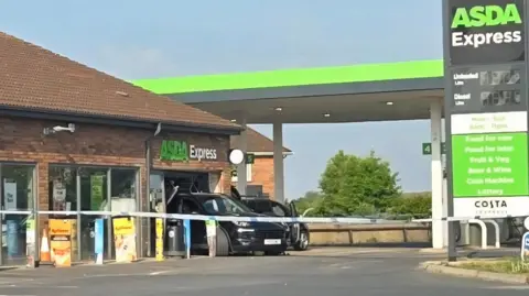 Dawn Wright A Porsche Cayenne that is reversed into a shop window at an Asda Express petrol station. Police tape is across the forecourt.