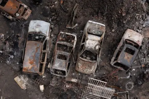 Cars destroyed by fire in a yard on July 25, 2022 in Wennington, Greater London