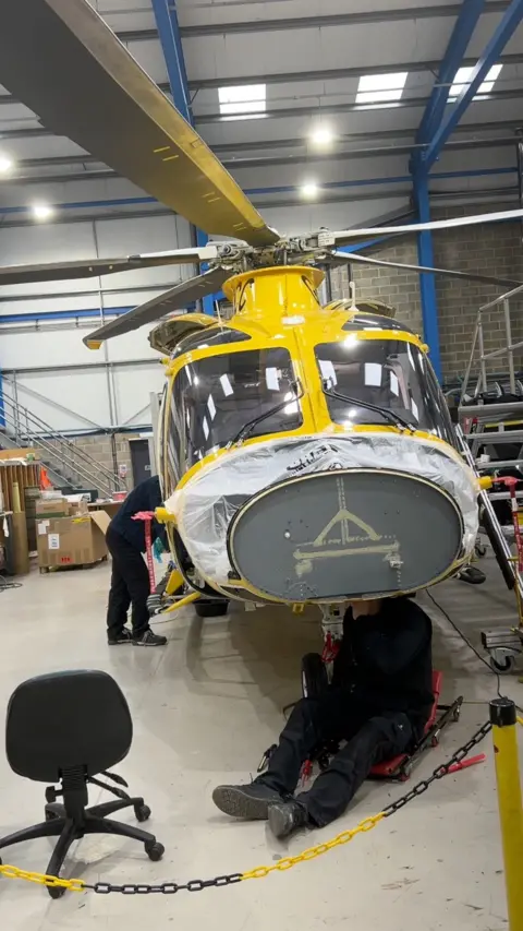 Helicopter being worked on in hangar.