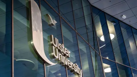 A glass building with a sign reading Ulster University