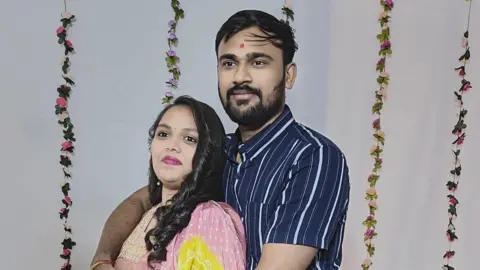 Hardik Avaiya with Vibhooti Patel looking at the camera 
