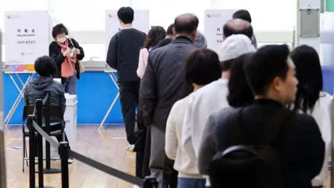 YONHAP/EPA Voters queue to cast their ballot at a polling station in southern Seoul on 10/4/2024