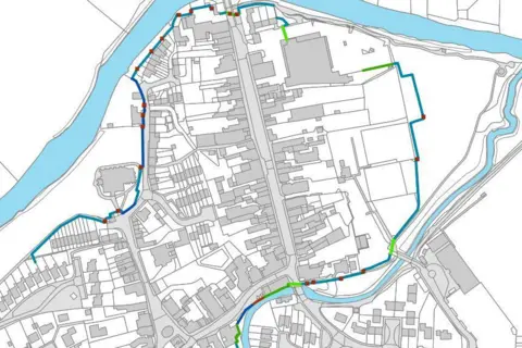 Environment Agency A black and white map shows the layout of Tenbury town centre, between the Kyre Brook and river Teme. Surrounding the town centre to the west, north and east is a line showing the route the flood defences would take