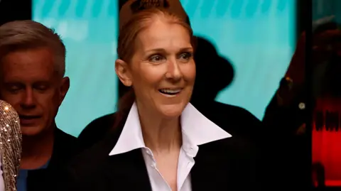 Celine Dion smiles arsenic  she walks retired  of the hotel