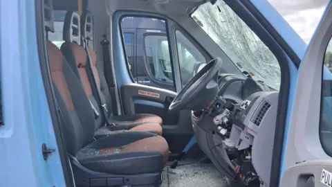 Priory Woods School & Arts College The inside of a van is covered in broken glass from a badly damaged windscreen. Shards of glass cover the three seats and the floor underneath the steering wheel.