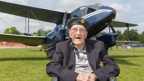 Arthur Clark sitting in front of Dragon Rapide plane