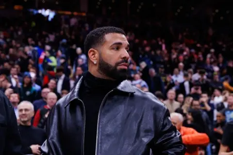 Getty Images Drake in a leather jacket while courtside at the Golden State Warriors v Toronto Raptors NBA game in January 2025