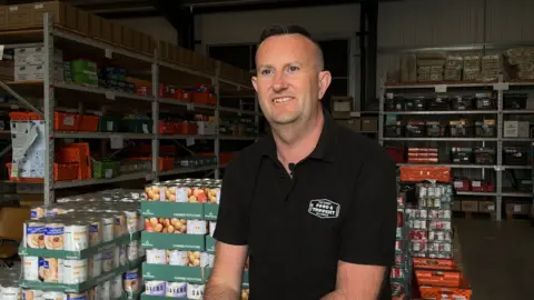 Paul Brookhouse sat inside a food bank warehouse