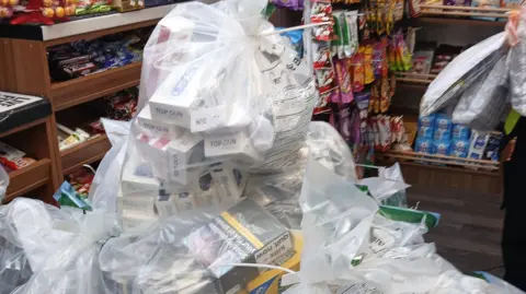 A pile of white plastic bags which contain tobacco products