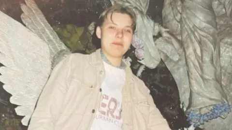 Picture of Izabela. She has short, fair hair and is wearing a beige jacket.