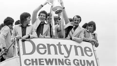 Getty Images A black and white image from 1976 of Saints players on the bus parade holding the FA Cup aloft.