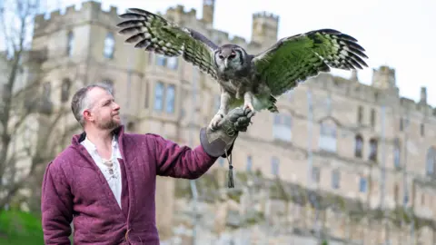 Warwick Castle/PA Wire Ernie the owl and handler