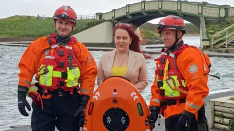 Beckie Ramsay Beckie Ramsay near open water in Fleetwood with two crew members from Lancashire Fire and Rescue Service.