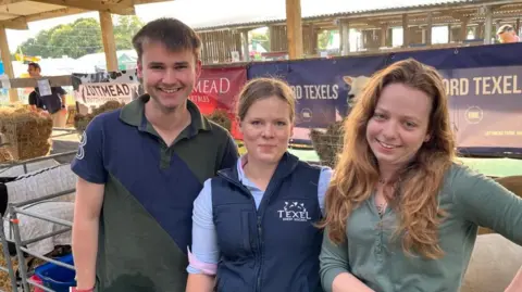 Phil Harrison/BBC A man in a green and blue top, a woman in a blue gillet and a woman in a green top.