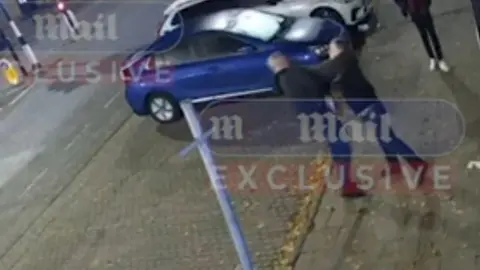 Daily Mail An image from a CCTV video shows one man punching another in the street