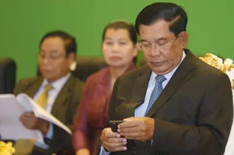 Reuters Cambodian Prime Minister Hun Sen checks his phone