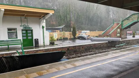 Matt Hill A wet Okehampton train station has large pieces of debris strewn across its platforms and the railway tracks during Storm Henk.