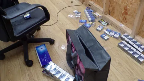 Leicestershire County Council Packets of cigarettes on a wooden floor